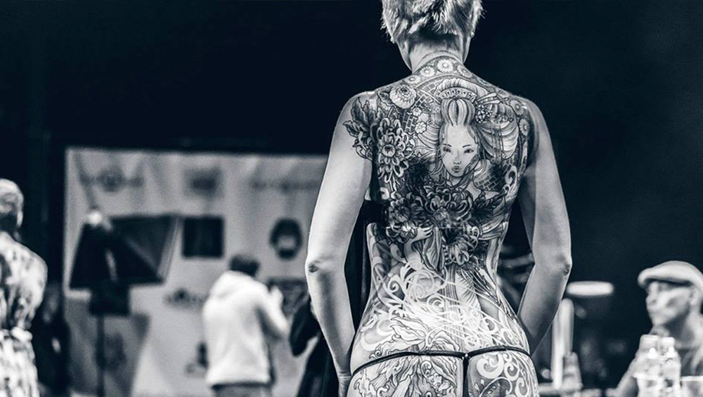 Женщина с татуировкой на фестивале тату в МСК