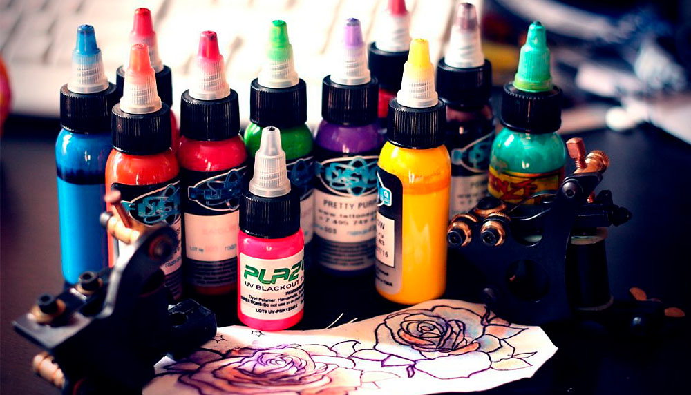 Инструменты и краски для татуировки на столе.