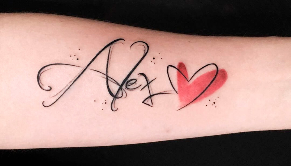 Рука с татуировкой сердца с именем.