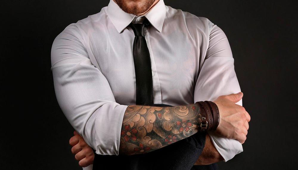 Мужчина с татуировкой анкера на руке, символизирующей надежду и стабильность